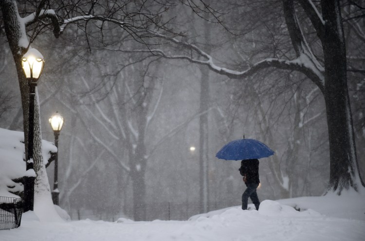 A pedestrian walks through New York City's snow-covered Central Park. Forecasters and managers at the National Weather Service are not getting paid during the partial government shutdown.