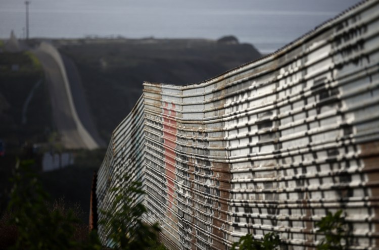 A section of a wall on the Mexican border stretches toward the Pacific Ocean near Tijuana, Mexico. In Washington, the standoff over President Trump's demand for funding for a new wall continued Tuesday.