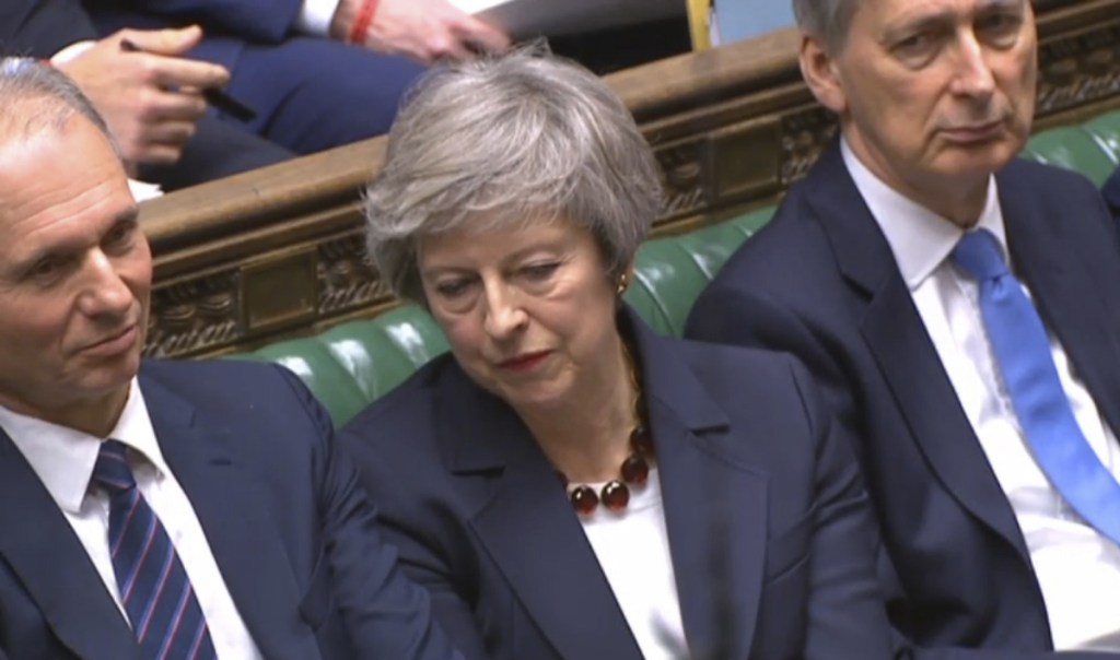 In this grab taken from video, Britain's Prime Minister Theresa May, centre, listens during Prime Minister's Questions in the House of Commons, London, Wednesday, Jan. 9, 2019.  The British government brought its little-loved Brexit deal back to Parliament on Wednesday, a month after postponing a vote on the agreement to stave off near-certain defeat. (House of Commons/PA via AP)