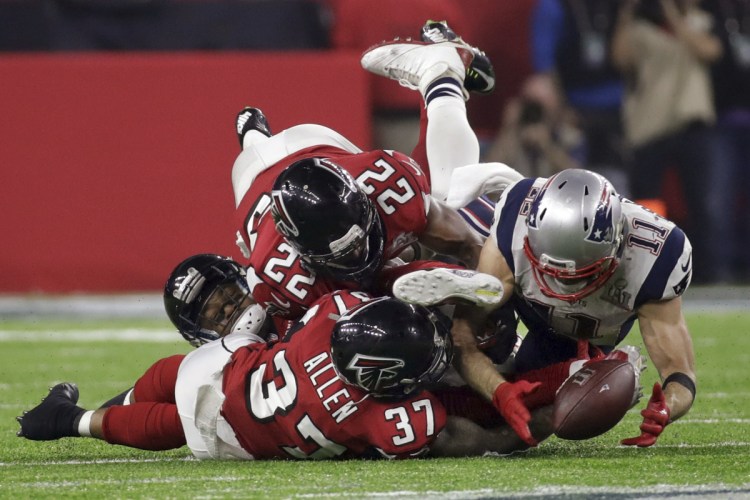 2017 AP YEAR END PHOTOS - New England Patriots' Julian Edelman makes a catch as Atlanta Falcons' Ricardo Allen and Keanu Neal defend, during the second half of the NFL Super Bowl 51 football game on Feb. 5, 2017, in Houston. (AP Photo/Patrick Semansky)