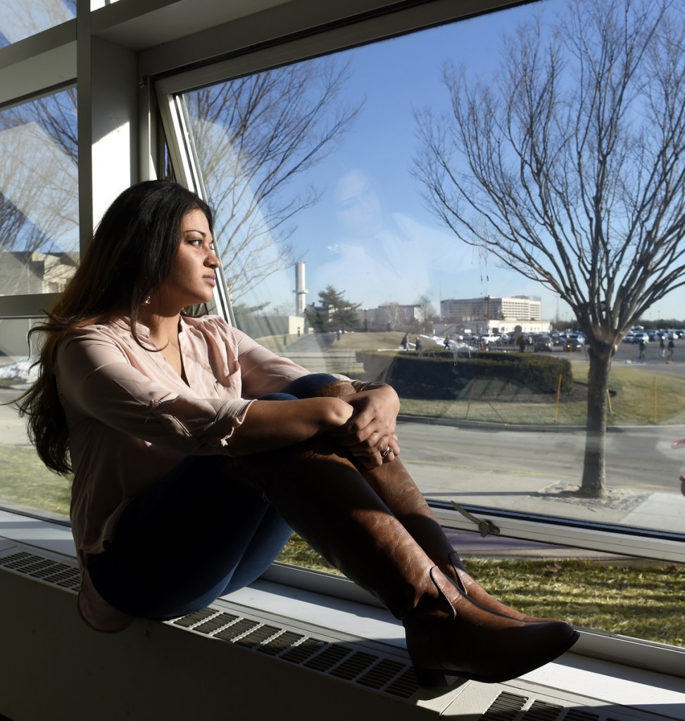 Naila Amin, 26, looks out from a window at Nassau Community College in Garden City, N.Y. "My passport ruined my life," said Amin, a dual citizen from Pakistan who was forcibly married at 13 and applied for papers for her 26-year-old husband to come to this country.