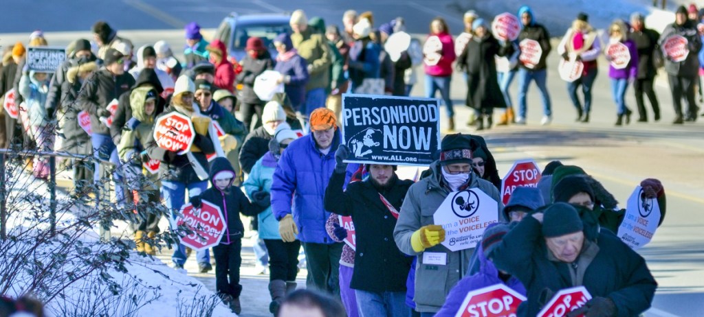 Mainers who favor restricting abortion rights walk Saturday from St. Michael School in Augusta to the Capitol building.
