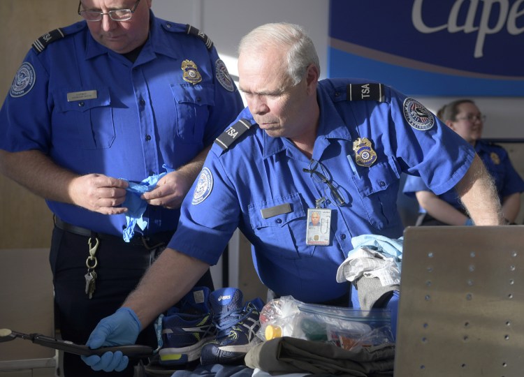 Transportation Security Administration screeners examine luggage at the Augusta State Airport. The federal employees are deemed essential so they have been working without pay since Dec. 22, when the federal government was shut down. "They're dedicated public servants," said an official with their union.