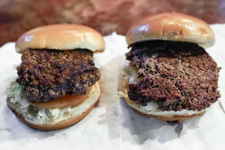 A conventional beef burger, left, is seen next to "The Impossible Burger", a plant-based burger containing wheat protein, coconut oil and potato protein among it's ingredients. The ingredients of the Impossible Burger are clearly printed on the menu at Stella's Bar & Grill in Bellevue, Neb., where the meat and non-meat burgers are served. More than four months after Missouri became the first U.S. state to regulate the term "meat" on product labels, Nebraska's powerful farm groups are pushing for similar protection from veggie burgers, tofu dogs and other items that look and taste like meat. 