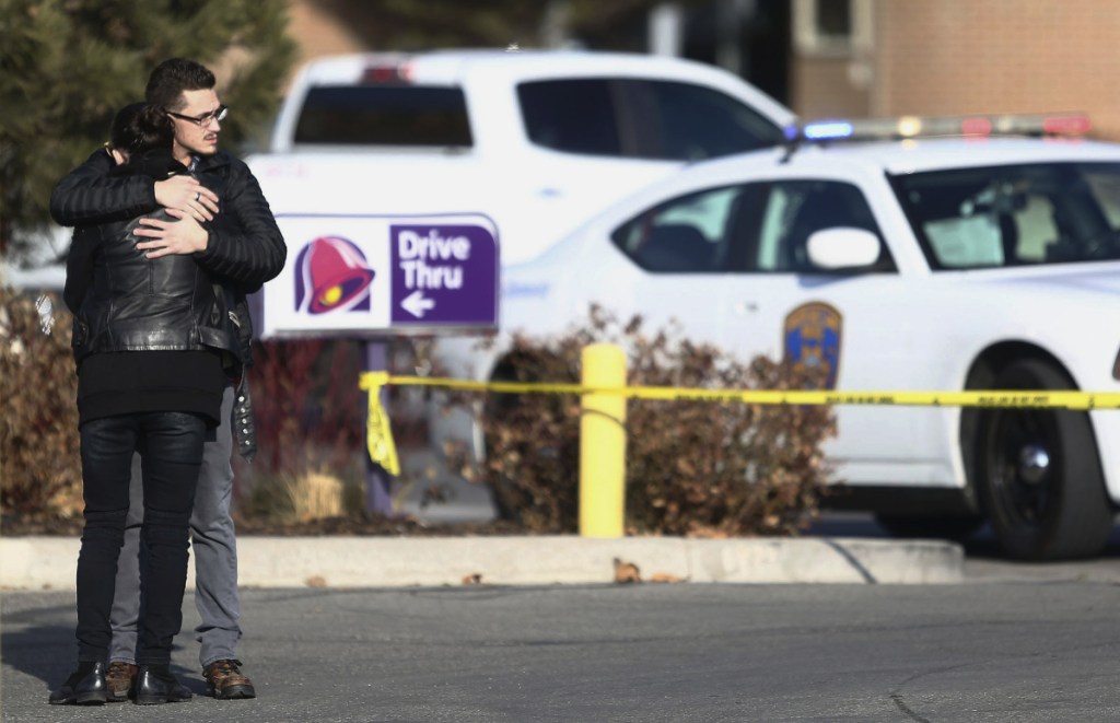 A man and woman embrace as police investigate a shooting at the Fashion Place mall in Murray, Utah on Sunday.