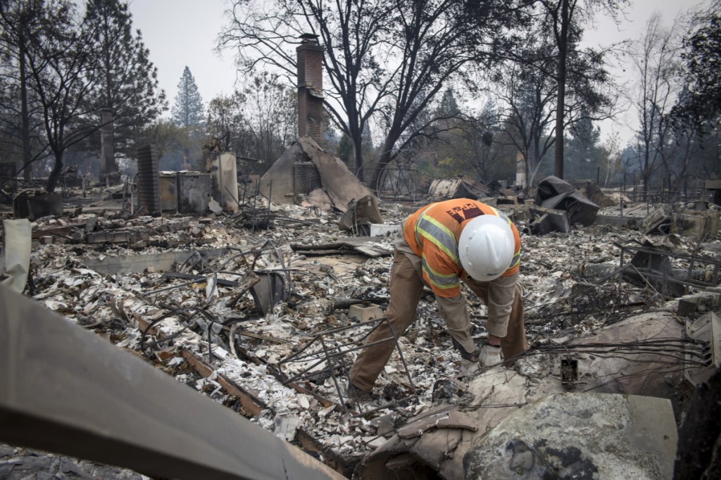 A Pacific Gas and Electric Co. worker locates a gas main line in front of a home during the Camp Fire in Paradise, Calif., in November.