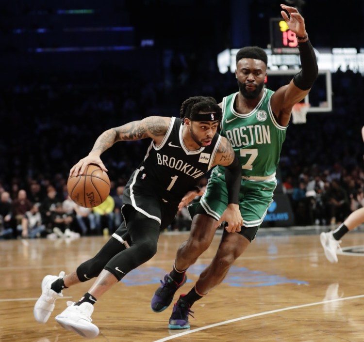 Brooklyn's D'Angelo Russell drives past Boston's Jaylen Brown during the first half of the Nets' 109-102 win Monday in New York.