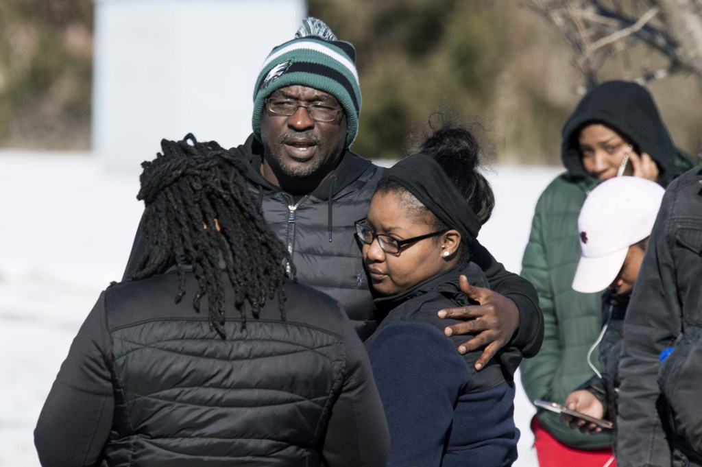People stand outside the UPS building in Logan Township, N.J., where police say William Owens, 39, held two women hostage Monday. Police shot Owens as he and the women left the building.