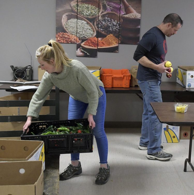 Augusta Food Bank staff members Melissa Shea and Andy Waller collect items for customers Tuesday. Several food security groups in central Maine have opened their doors to federal employees who have gone unpaid since December.