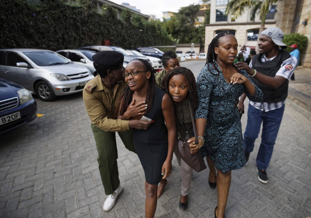 Civilians flee the scene at a hotel complex in Nairobi, Kenya, on Tuesday. An upscale hotel complex in Kenya's capital came under attack on Tuesday, with a blast and heavy gunfire. The al-Shabab extremist group based in neighboring Somalia claimed responsibility and said its members were still fighting inside.