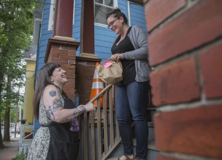 Salli Wason, left, owner of Rosanna's Ice Cream, delivers ice cream to Ann-Marie Keene in Portland in 2017. Rosanna's is closing.