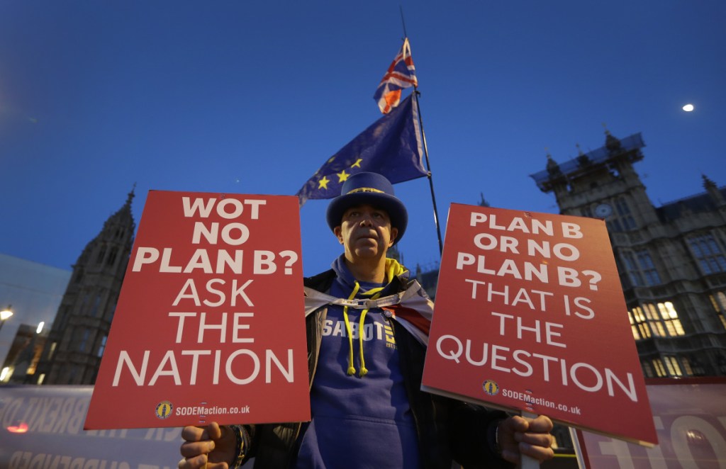 A pro-European demonstrator holds banners near Parliament in London on Thursday. British Prime Minister Theresa May is reaching out to opposition parties and other lawmakers in a battle to put Brexit back on track after surviving a no-confidence vote. (AP Photo/Kirsty Wigglesworth)