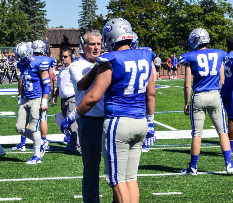 Staff photo by Joe Phelan 
 New Colby College head football coach Jack Cosgrove talks with a player before a game against Trinity on Saturday in Waterville.