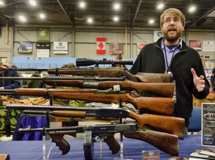 Dave Hayward, of Poulin Antiques and Auctions, talks about antique rifles on display during a gun show Saturday at the Augusta Civic Center.