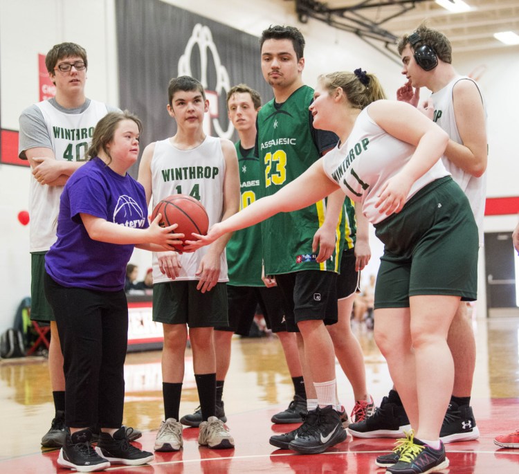Samantha Neumann of Winthrop hands the ball to an opponent from Waterville for another shot at the Unified basketball tournament Saturday.