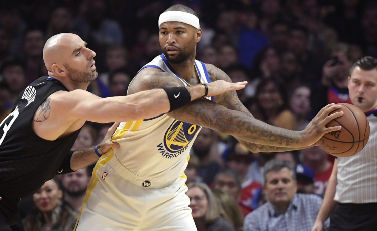 DeMarcus Cousins, right, posts up against Clippers center Marcin Gortat during Golden State's 112-94 win Friday night. Cousins made his debut with Golden State and scored 14 points to help the Warriors in their seventh straight victory.