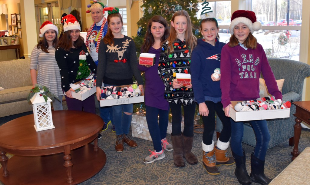 Wells Junior High School students make a holiday visit to Avita of Wells to deliver handmade snowmen and personalized greeting cards to 68 residents. The visit was part of the school's service learning project. From left, students Melody Goodwin and Belle Norton, Renèe Savage, and students Logan Blanchard, Catie Kasabinski, Molly Tavares, Jessica Palmer and Teagan Hludik.