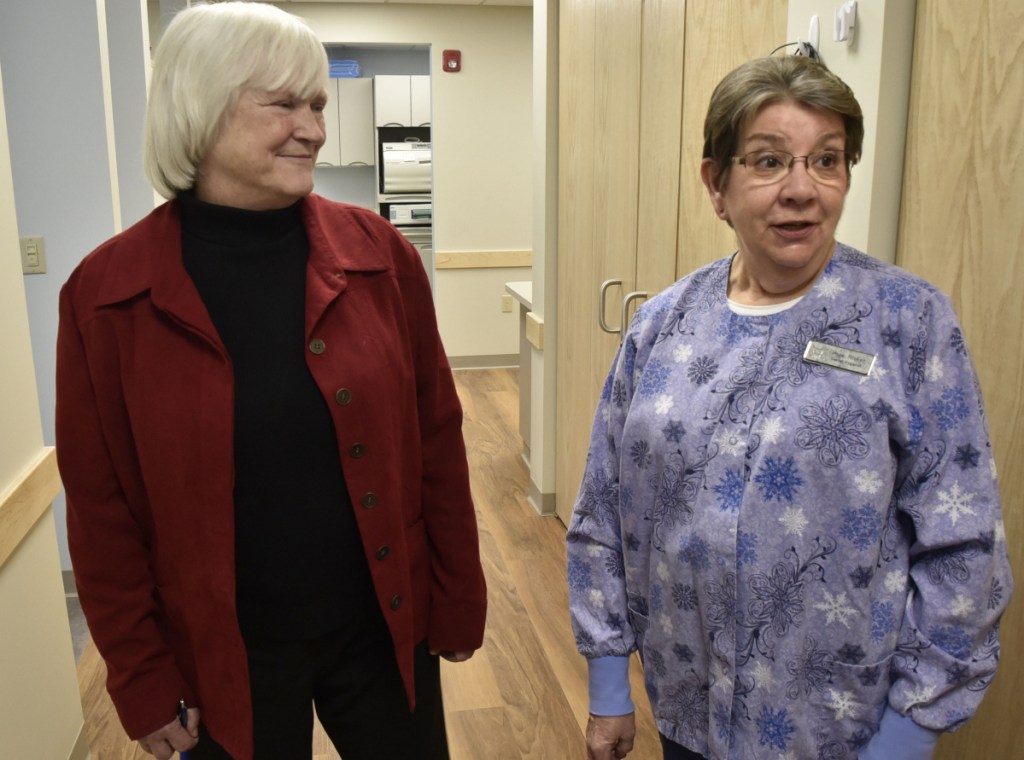 Dr. Barbara Covey, left, chairman of the board of the Waterville Community Dental Center, listens as dental hygienist Hope Ricker points out the benefits of the new facility located in FirstPark in Oakland, including the larger space and more accessible parking.