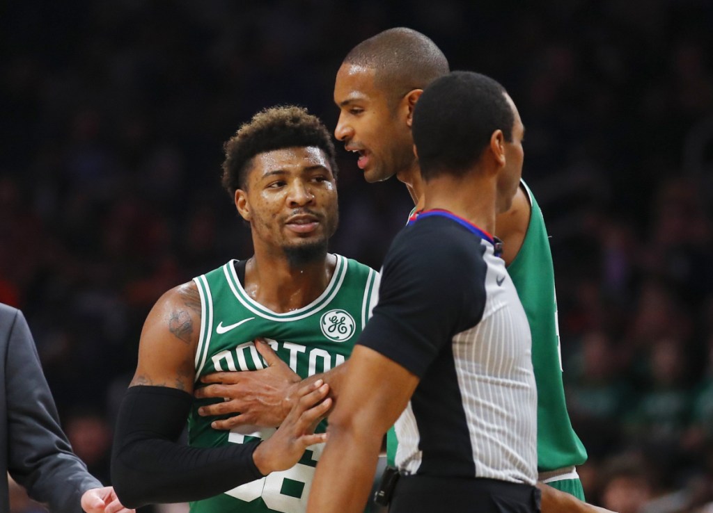 Marcus Smart of the Boston Celtics is restrained by center Al Horford after being ejected Saturday night during a 113-105 victory against the Atlanta Hawks.