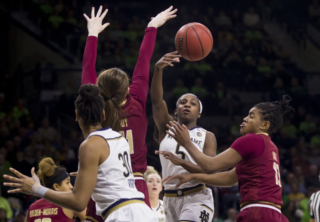 Jackie Young of Notre Dame passes the ball between Emma Guy, left, and Taylor Soule of Boston College in the second half of Notre Dame's 92-63 win Sunday.
