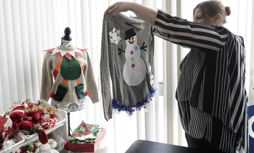Doris Cochran holds "an ugly sweater," which she is planning to sell, last Friday in her apartment. She is a disabled mother of two young boys living in subsidized housing in Arlington, Va.