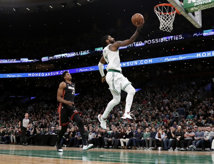 Boston's Kyrie Irving, right, goes in for a layup past Miami's Hassan Whiteside during the second quarter of the Celtics 107-99 win Monday in Boston.