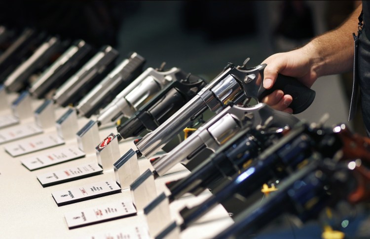 Handguns are displayed at the Smith & Wesson booth at the Shooting, Hunting and Outdoor Trade Show in Las Vegas in 2016. Without having former President Barack Obama in office, gun advocates lack a clear foe, culminating in fewer firearms sales.