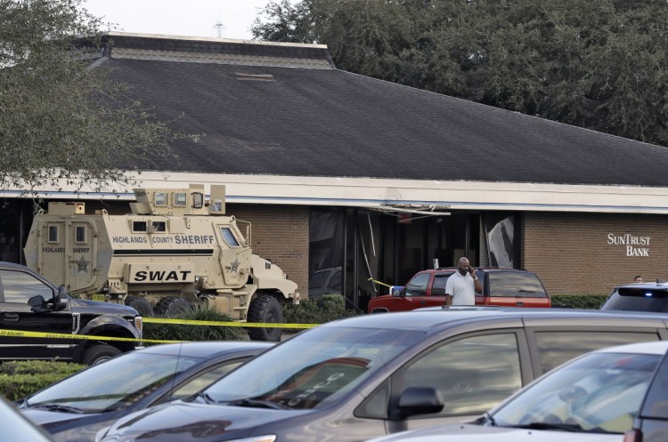 A Highlands County Sheriff's SWAT vehicle is stationed in front of a SunTrust Bank branch Wednesday in Sebring, Fla., where authorities say five people were shot and killed.