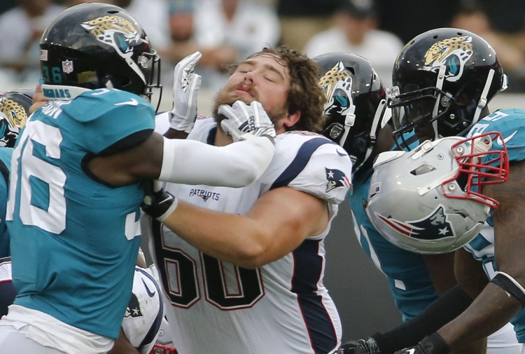 New England center David Andrews gets his helmet knocked off as he blocks Jacksonville's Ronnie Harrison in a Sept. 16 game. Andrews won a Super Bowl with New England against Atlanta, and lost one last year against the Eagles.