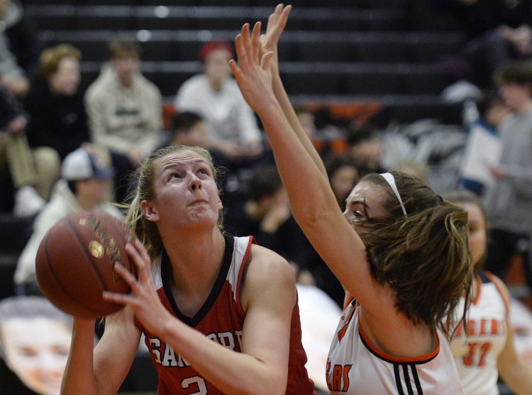 Paige Cote of Sanford prepares to shoot Friday night while guarded by Grace Martin of Biddeford during Sanford's 48-45 victory in an SMAA game on the road.