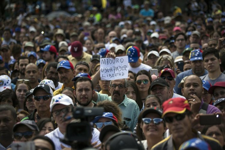 A man holds a sign with a message that reads in Spanish: "Maduro, Usurper. Freedom" during an opposition rally in Las Mercedes neighborhood of Caracas, Venezuela, on Saturday.
