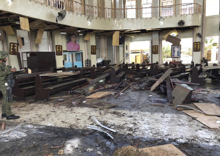 A soldier views the site inside a Roman Catholic cathedral in Jolo, the capital of Sulu province in the southern Philippines, after two bombs exploded Sunday.