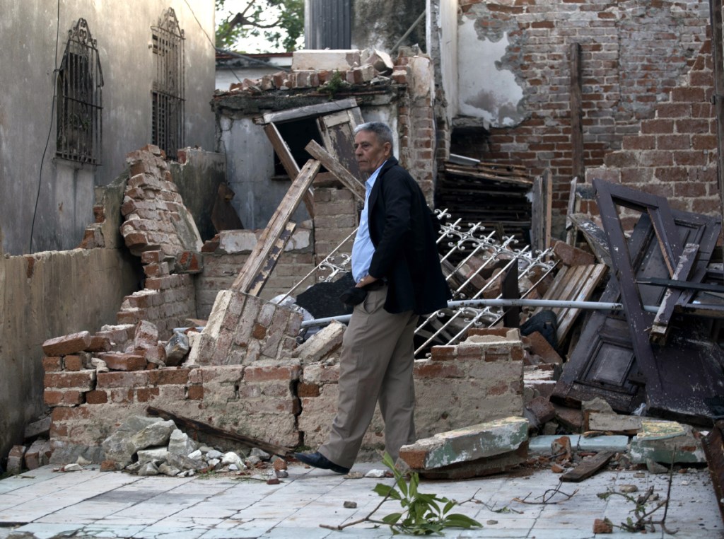 A man walks in a home that was destroyed by a tornado in Havana, Cuba, Monday, Jan. 28, 2019. A tornado and pounding rains smashed into the eastern part of Cuba's capital overnight, toppling trees, bending power poles and flinging shards of metal roofing through the air as the storm cut a path of destruction across eastern Havana. (AP Photo/Ramon Espinosa)