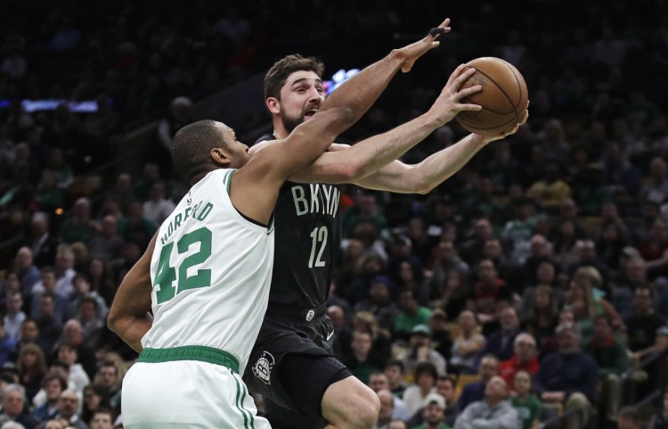 Boston's Al Horford tries to block a shot by Brooklyn's Joe Harris during the Celtics' 112-104 win Monday in Boston. The Celtics blocked 16 shots.