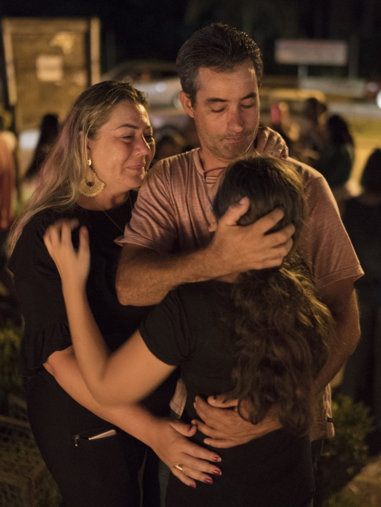 A family embraces during a vigil for the dam victims in Brumadinho, Brazil, Tuesday. Authorities arrested five people Tuesday in connection with the collapse of the dam, while the death toll rose to at least 84 and the carcasses of fish floated along the banks of a river downstream that an indigenous community depends on for food and water.
