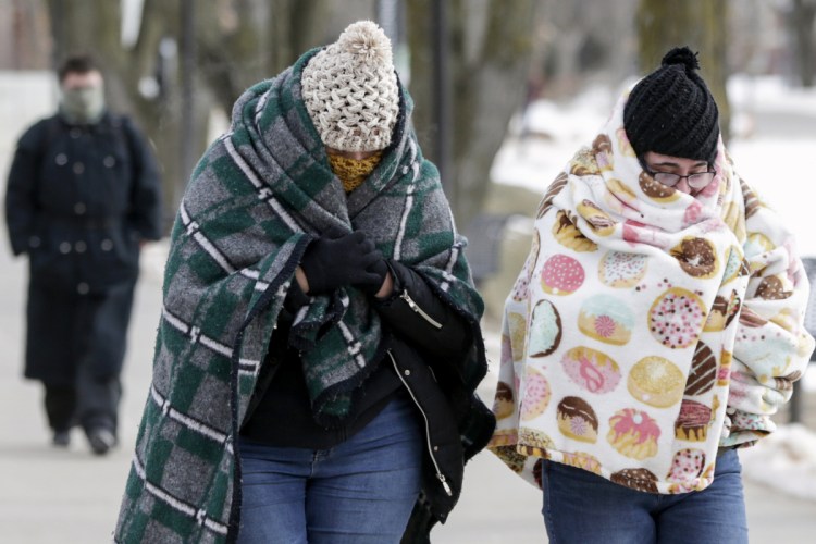 Pedestrians bundle up in sub-freezing temperatures on the campus of the University of Nebraska-Omaha, in Omaha, Nebraska, on Wednesday. A deadly arctic deep freeze enveloped the Midwest with record-breaking temperatures, triggering widespread closures of schools and businesses, and the canceling of more than 1,600 flights.