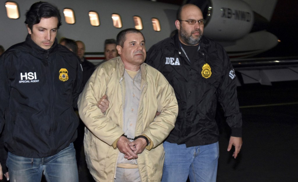 U.S. law enforcement officers escort Joaquin "El Chapo" Guzman from a plane at Long Island MacArthur Airport, in Ronkonkoma, N.Y. Prosecutors made closing arguments in the 12-week trial on Wednesday.