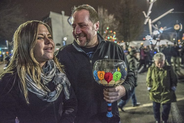 Heather Martel and Rodney Robichaud listen to a band playing on the stage at Auburn's New Year's Eve celebration on Monday.