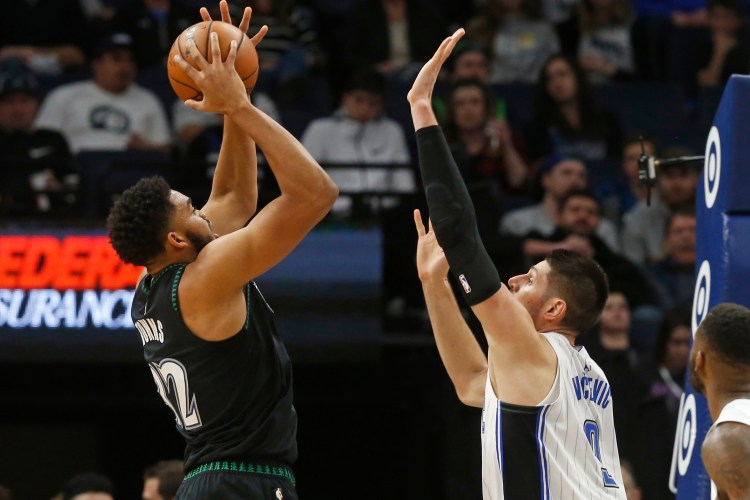 Minnesota Timberwolves' Karl-Anthony Towns, left, shoots over Orlando Magic's Nikola Vucevic during the Timberwolves 120-103 win Friday in Minneapolis. 