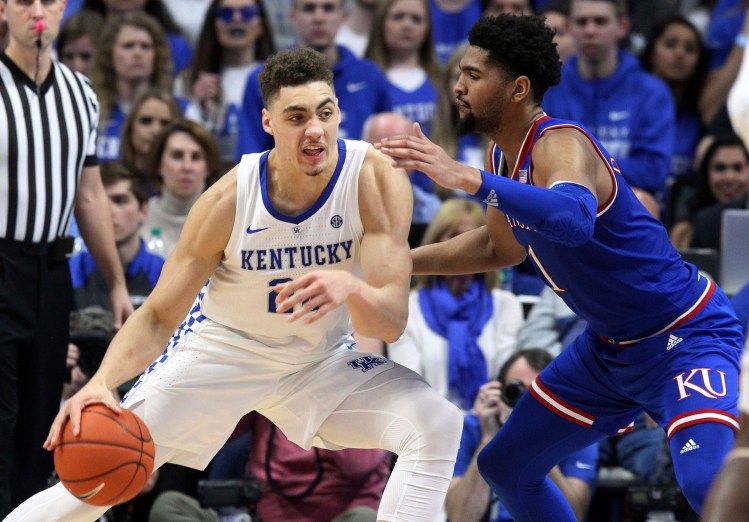 Kentucky's Reid Travis (22) drives on Kansas' Dedric Lawson during the second half of the Wildcats' 71-63 win Saturday in Lexington, Ky.