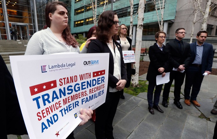 Plaintiffs Cathrine Schmid, second left, and Conner Callahan, second right, listen with supporters during a news conference in front of a federal courthouse following a hearing in Seattle on March 27, 2018. Transgender-rights activists were angered at moves by President  Trump and his administration to undermine gains achieved before his election. Trump is seeking to ban transgender people from military service.