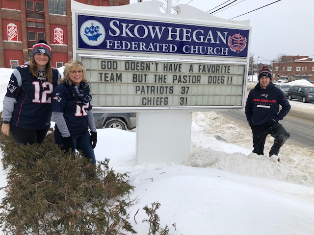 Kaley Brown, daughter of the Rev. Mark Tanner, his wife, Deb, and son Josh Tanner stand by the Skowhegan Federated Church sign Monday. The message was put up Friday, correctly predicting the New England Patriots' victory in Sunday night's AFC title game and the final score, 37-31. 