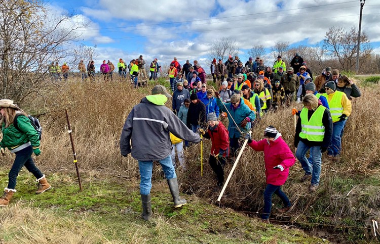 Volunteers cross a creek and barbed wire near Barron, Wis. on Oct. 23, on their way to a ground search for 13-year-old Jayme Closs who was discovered missing Oct. 15 after her parents were found fatally shot at their home. 