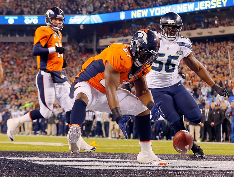 Denver Broncos Knowshon Moreno reaches for a loose ball in the end zone after the snap sailed past quarterback Peyton Manning, left, on the first play from scrimmage in Super Bowl XLVIII, Feb. 2, 2014. The Seahawks never looked back, winning 43-8 for their first Super Bowl championship. 