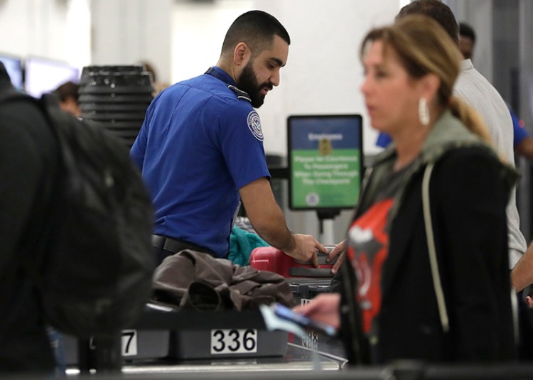 A Transportation Security Administration officer works at a checkpoint at Miami International Airpor on Jan. 6. 