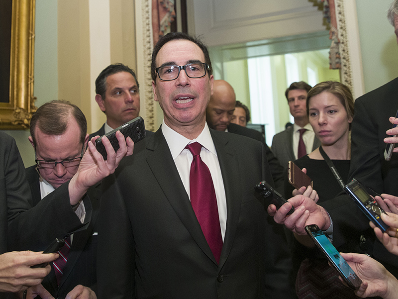 Treasury Secretary Steve Mnuchin, center, speaks with reporters as he departs the Republican policy luncheon on Capitol Hill, on Tuesday.