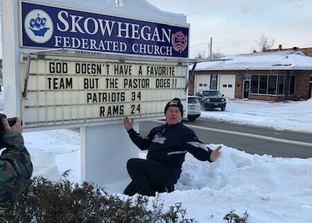 The Rev. Mark Tanner unveils his prediction for Sunday's Super Bowl outside his Skowhegan Federated Church on Thursday. Tanner correctly guessed the score of the AFC championship game and posted his prediction on the church sign in the runup to that game. 
