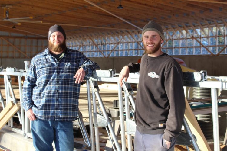 Dairy farmers Ben Jensen, left, and Matt DeGrandpre stand in one of several buildings that will make up the new dairy facility at Wolfe’s Neck.