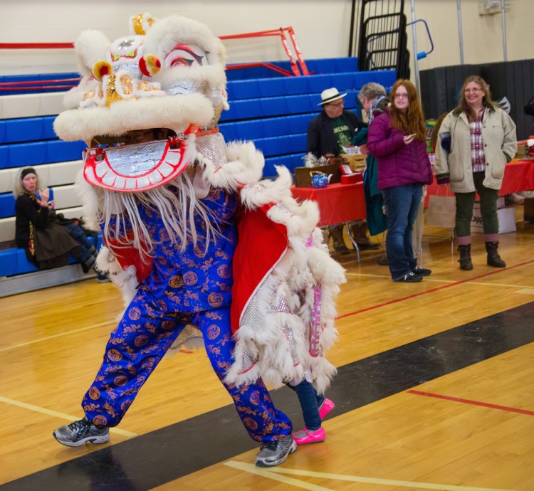 Participants perform the lion dance during a Chinese New Year celebration in the Westbrook Performing Arts Center on Saturday. The  lion is believed to chase away evil spirits and provide for a good year, according to one of the performers.