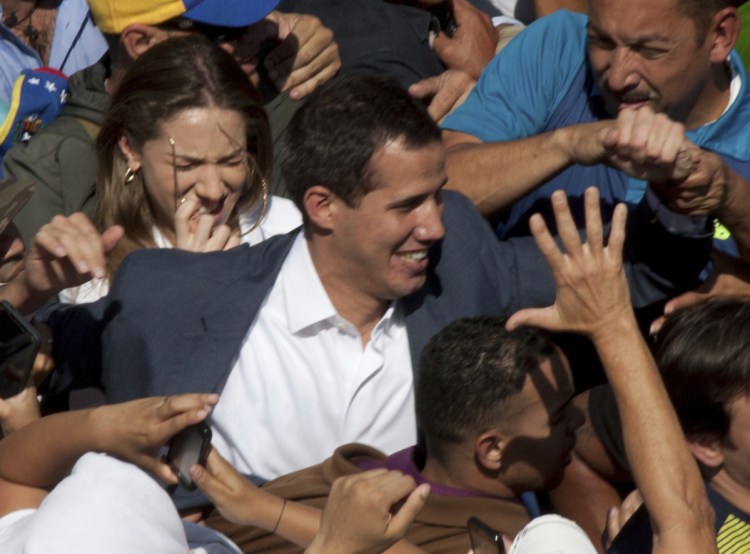Venezuelan opposition leader Juan Guaido greets supporters as he demands the resignation of President Nicolas Maduro.